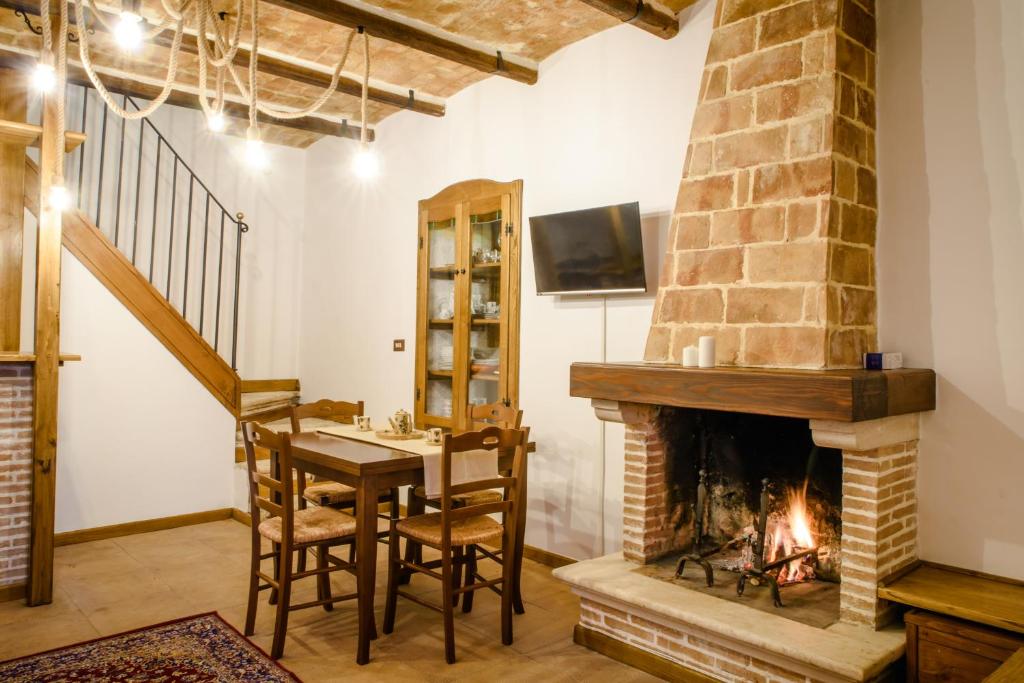 een woonkamer met een open haard en een tafel en stoelen bij LaVistaDeiSogni Monte Morrone in Celano