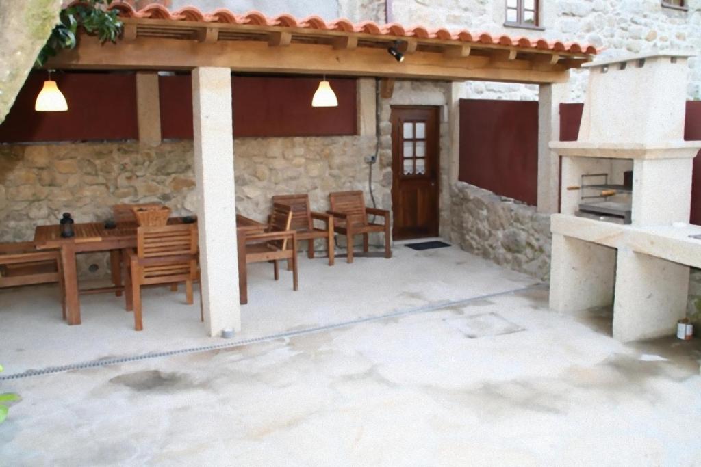 a patio of a house with a table and chairs at Casa da Avó in Sistelo