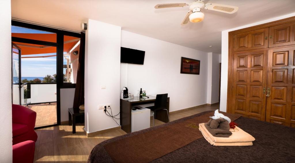a living room with a couch and a tv and a door at Hostal Casa Mercedes in Nerja