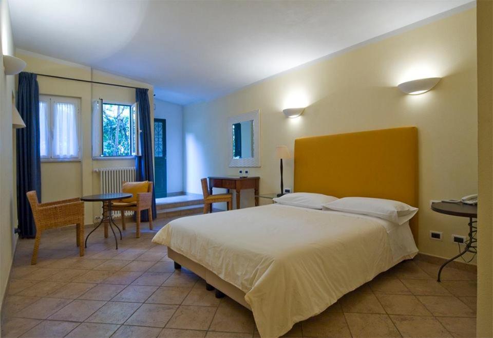 a bedroom with a large bed and a table and chairs at Locanda Conchiglia D'Oro in Varigotti