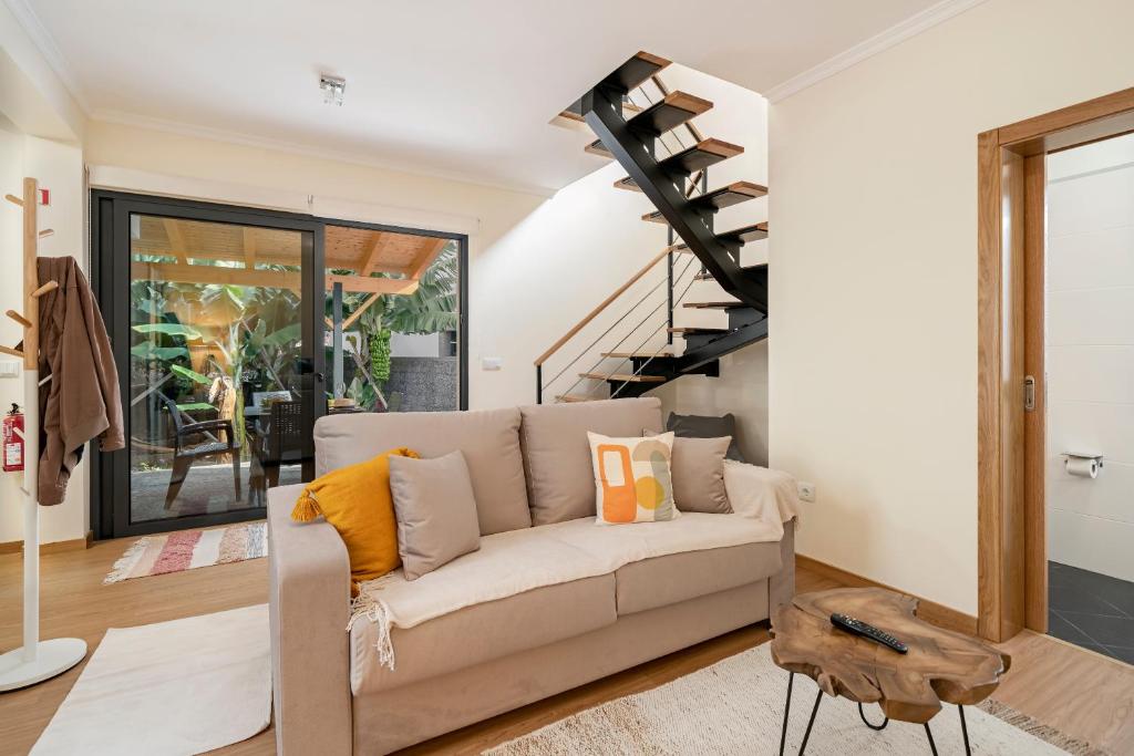 uma sala de estar com um sofá e uma escada em espiral em Oscar's House by An Island Apart em Ponta do Sol