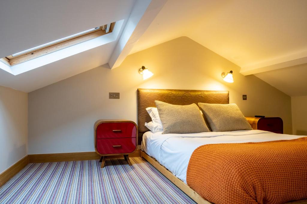 a hotel room with a bed and a red suitcase at The Vineyard Lamberhurst in Lamberhurst