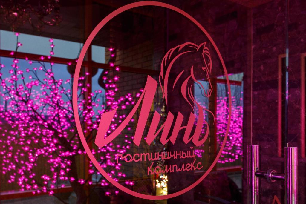 a neon sign in a window with pink lights at Гостиничный комплекс Линь in Burtsevo