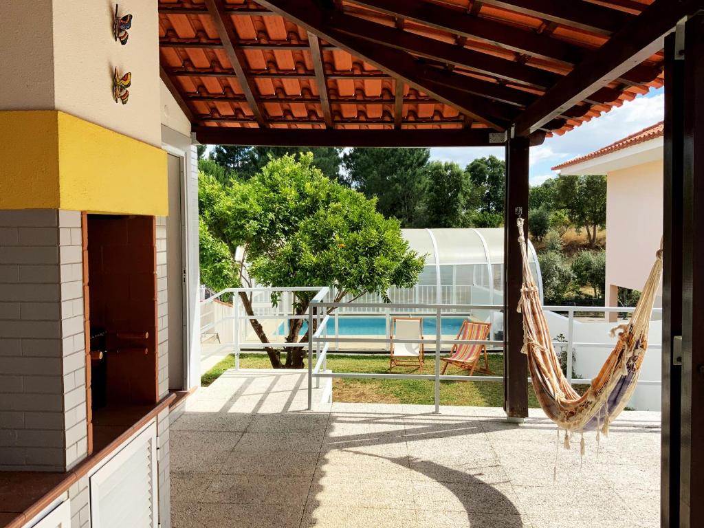 a patio with a hammock and a swimming pool at casa Jone olival in Tomar