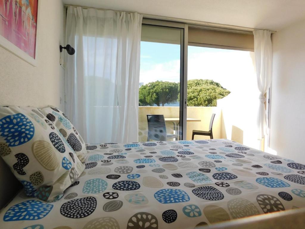 a bedroom with a bed with a large window at Studio climatisé 1 à 4 personnes vue mer in Le Grau-du-Roi