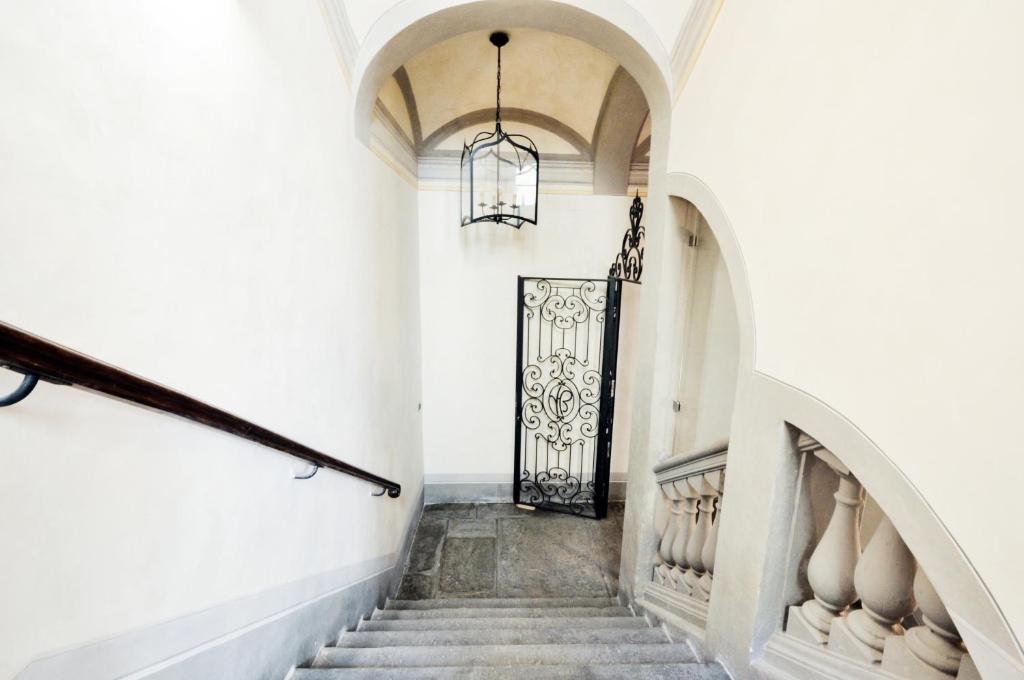 フィレンツェにあるTornaquinci Palaceの白い建物の黒い扉付きの階段