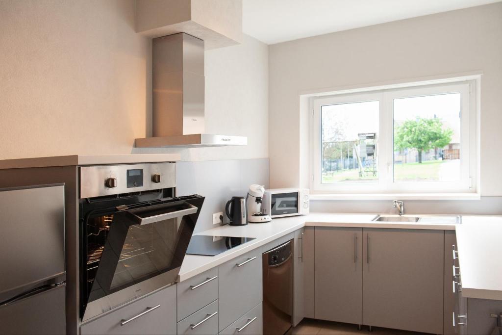 a kitchen with a stove top oven next to a window at LE TOMIGITE in Dimbsthal