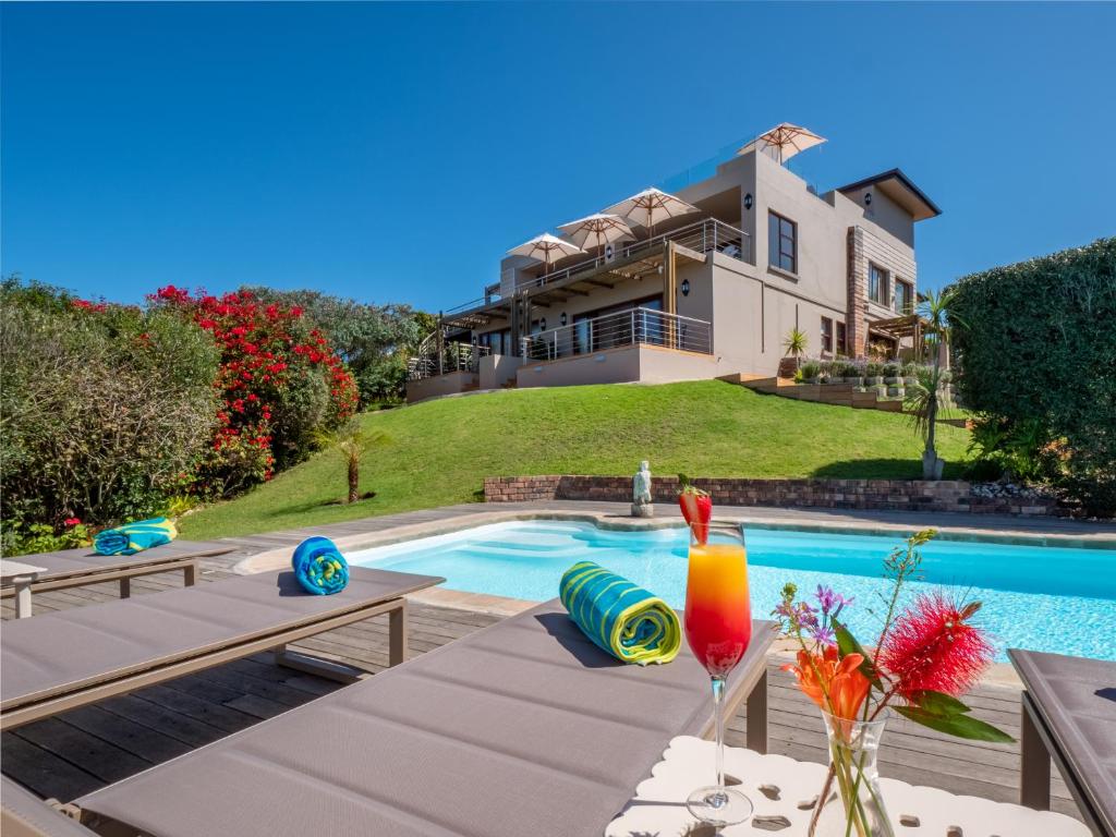 a villa with a swimming pool and a house at La Vista Lodge in Plettenberg Bay