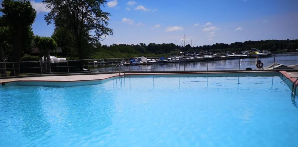 een groot zwembad met blauw water naast een jachthaven bij Lido di Sesto in Sesto Calende