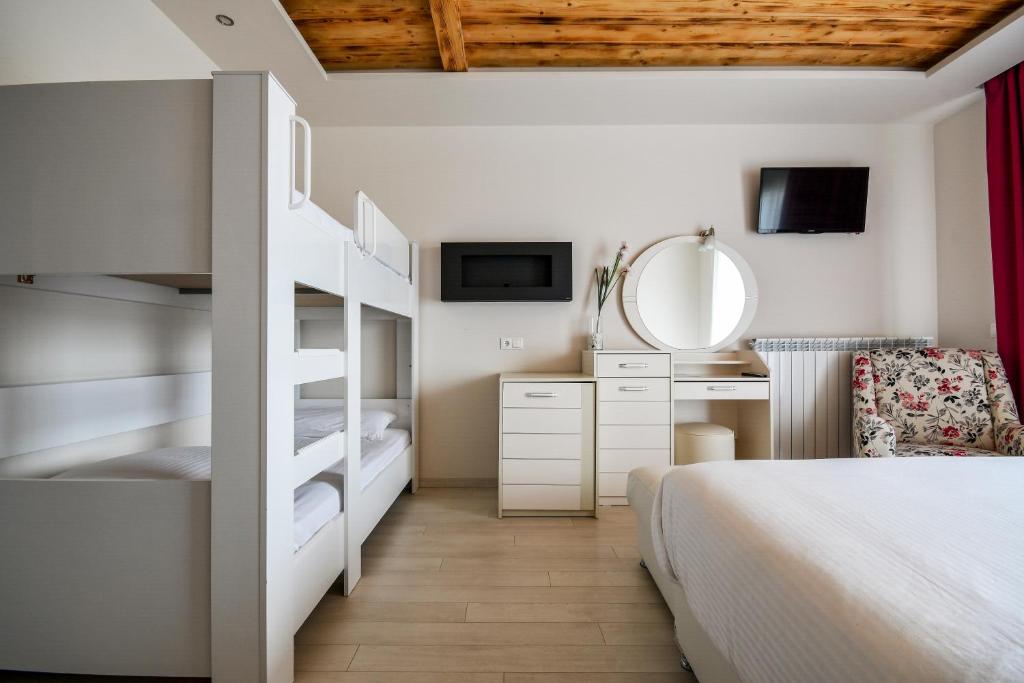 a bedroom with a bunk bed and a mirror at Archontiko Liamas in Stavros