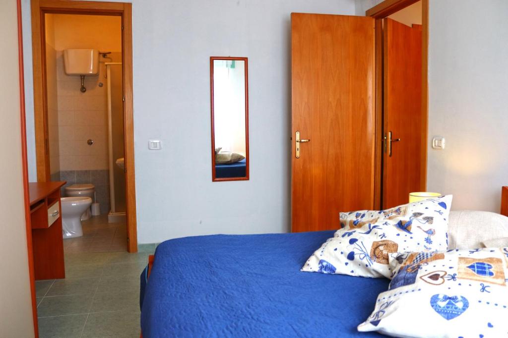 a bedroom with a blue bed and a bathroom at Holiday Apartment Karm Otranto 6 places in Otranto