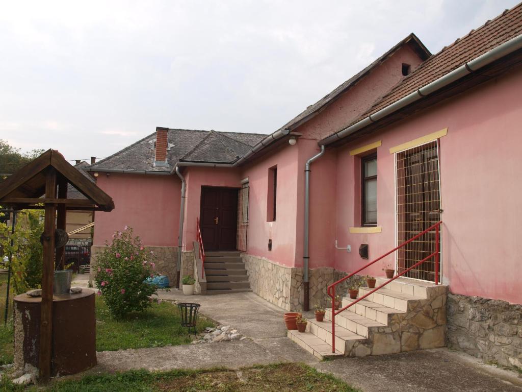 Bekölce的住宿－Hibiszkusz Haz，粉红色的房子,有门和门