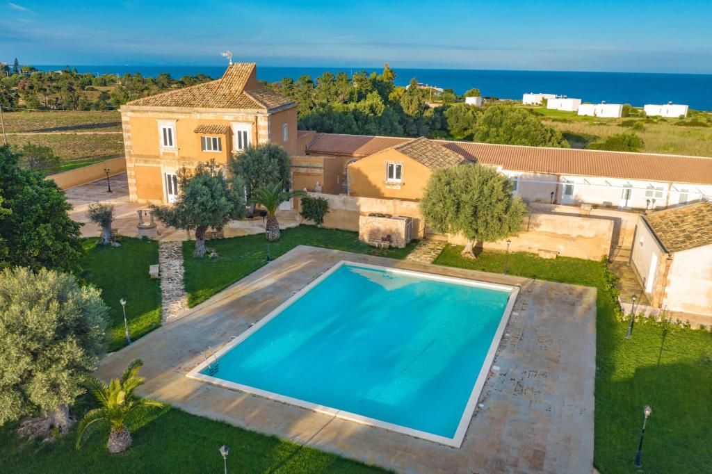 an aerial view of a house with a large swimming pool at Masseria Testaferrata in Siracusa