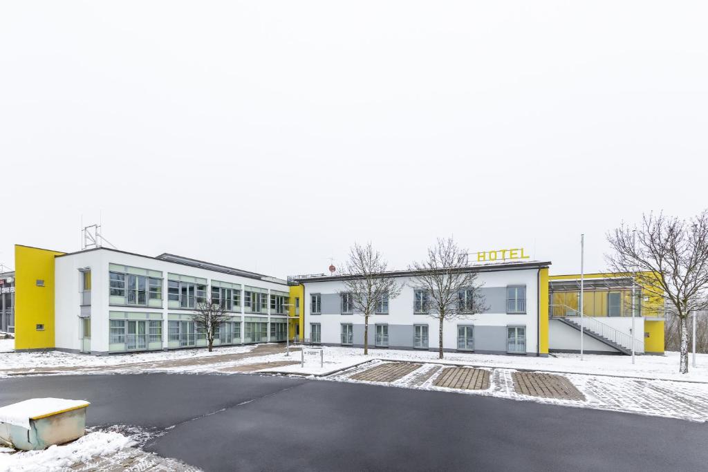 ein leerer Parkplatz vor einem Gebäude in der Unterkunft Hotel Fränkische Schweiz-Pegnitz in Pegnitz