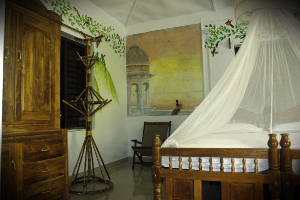 a bedroom with a canopy bed and a tripod at Jickys Nest in Varkala