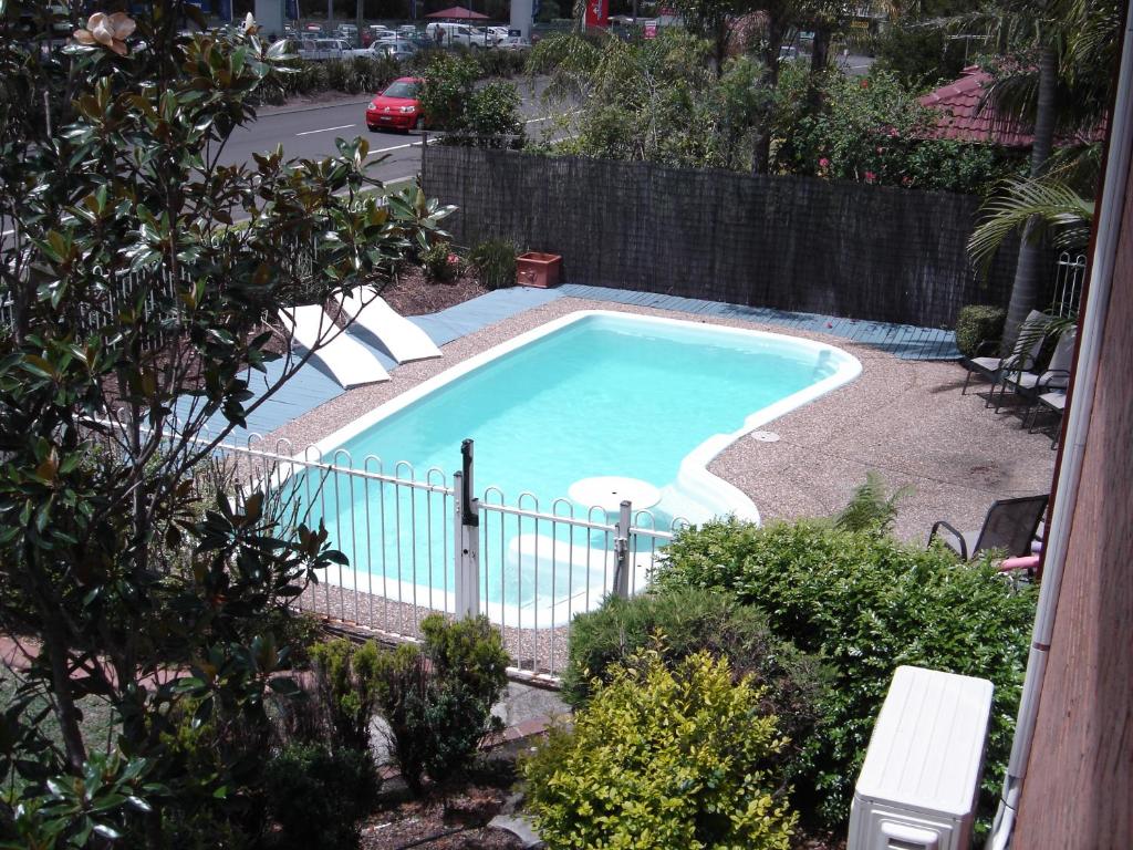 a swimming pool in a yard with a fence at Avaleen Lodge Motor Inn in Nowra