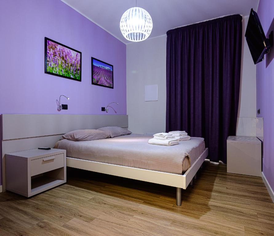 Dormitorio púrpura con cama y lámpara de araña en Millefiori, en Cagliari