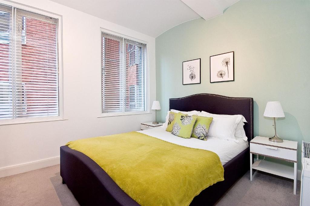 a bedroom with a bed with a yellow blanket at Mulberry Flat 2 - Two bedroom 1st floor by City Living London in London