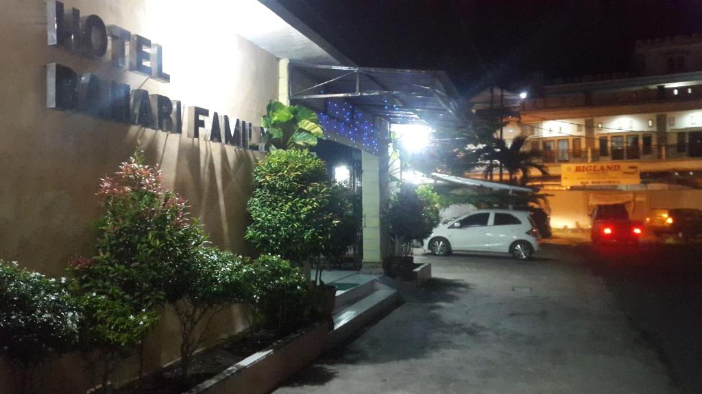 a white car parked in a parking lot at night at Bahari Family Hotel in Bitung