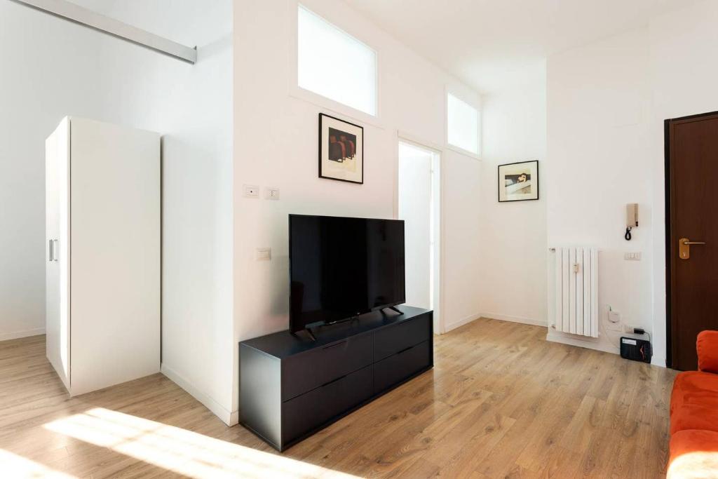 un soggiorno con TV a schermo piatto su un comò di Spacious flat close to Fondazione Prada & Metro a Milano