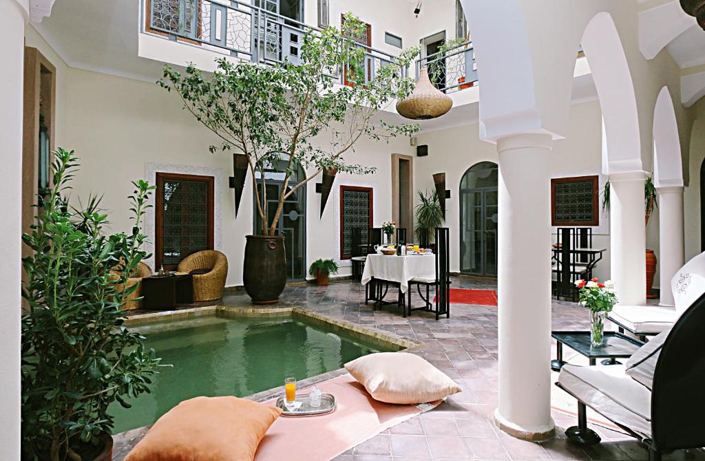 un patio con piscina en una casa en Riad Jardin Des Rêves, en Marrakech