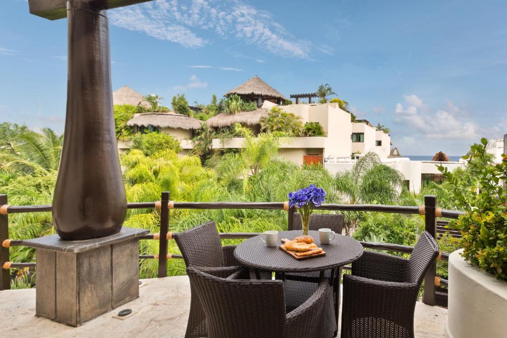 a table and chairs on a balcony with a view of a building at El Taj Oceanfront and Beachside Condo Hotel in Playa del Carmen