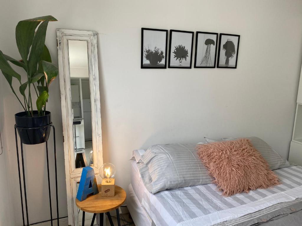 een slaapkamer met een bed en een spiegel en een plant bij Depto nuevo boutique, muy luminoso a 6 cuadras de la playa in Mar del Plata