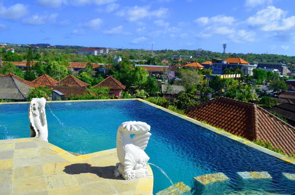 a swimming pool with a view of a city at Nirmala Hotel Jimbaran in Jimbaran