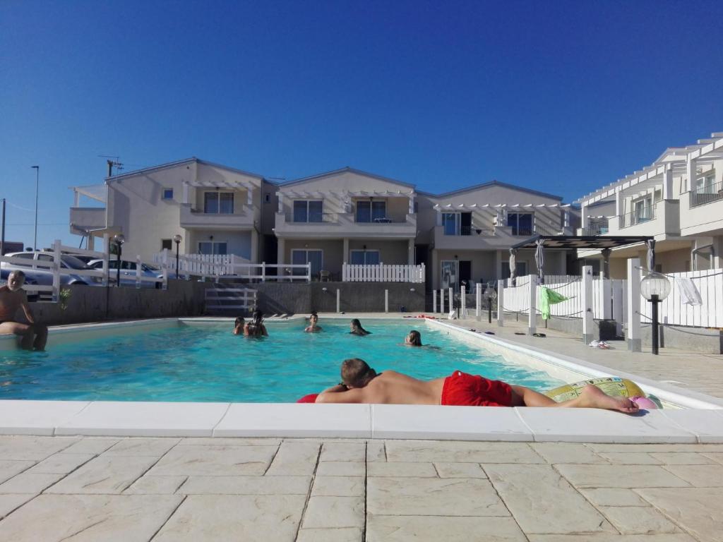 un hombre y una mujer tumbados en una piscina en Cala Sardinia Apartment, en Viddalba