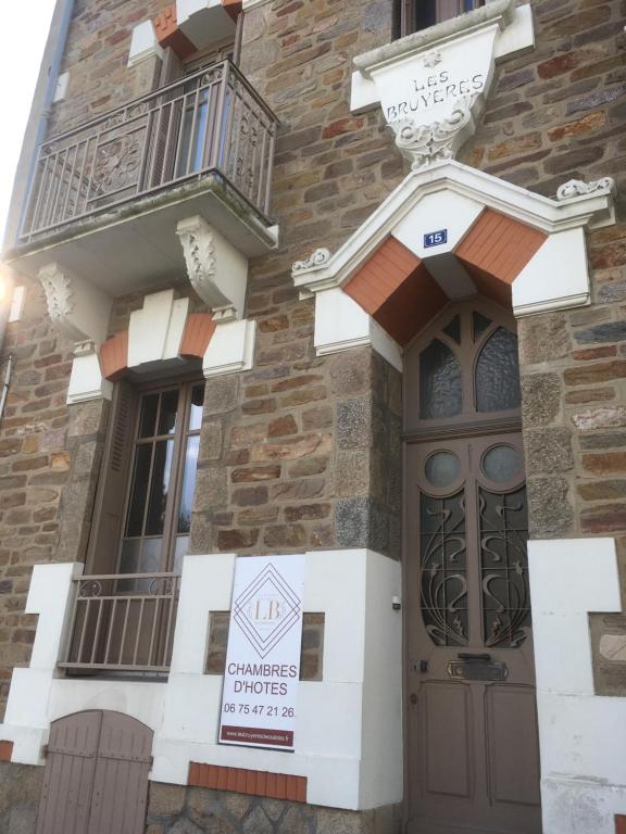 un edificio con una puerta y una señal en él en Les Bruyères, en Les Sables-dʼOlonne