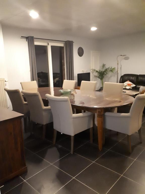uma sala de jantar com uma mesa de madeira e cadeiras brancas em jutta em Mechelen