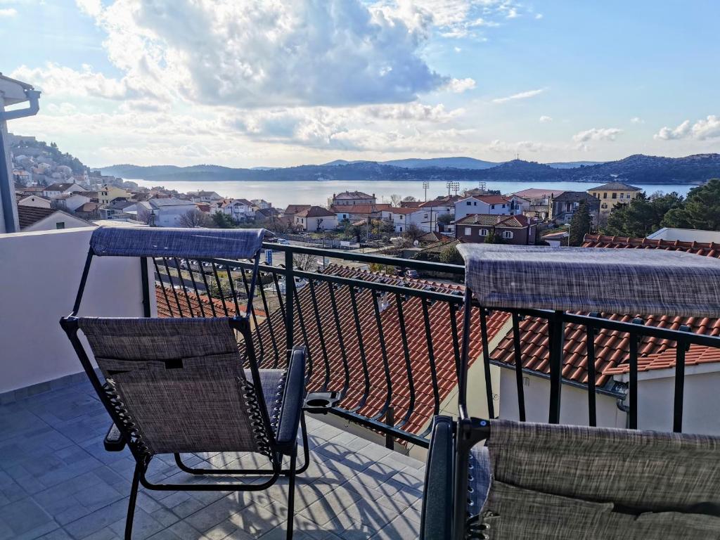 a balcony with chairs and a view of the water at Apartmani Krnić in Šibenik