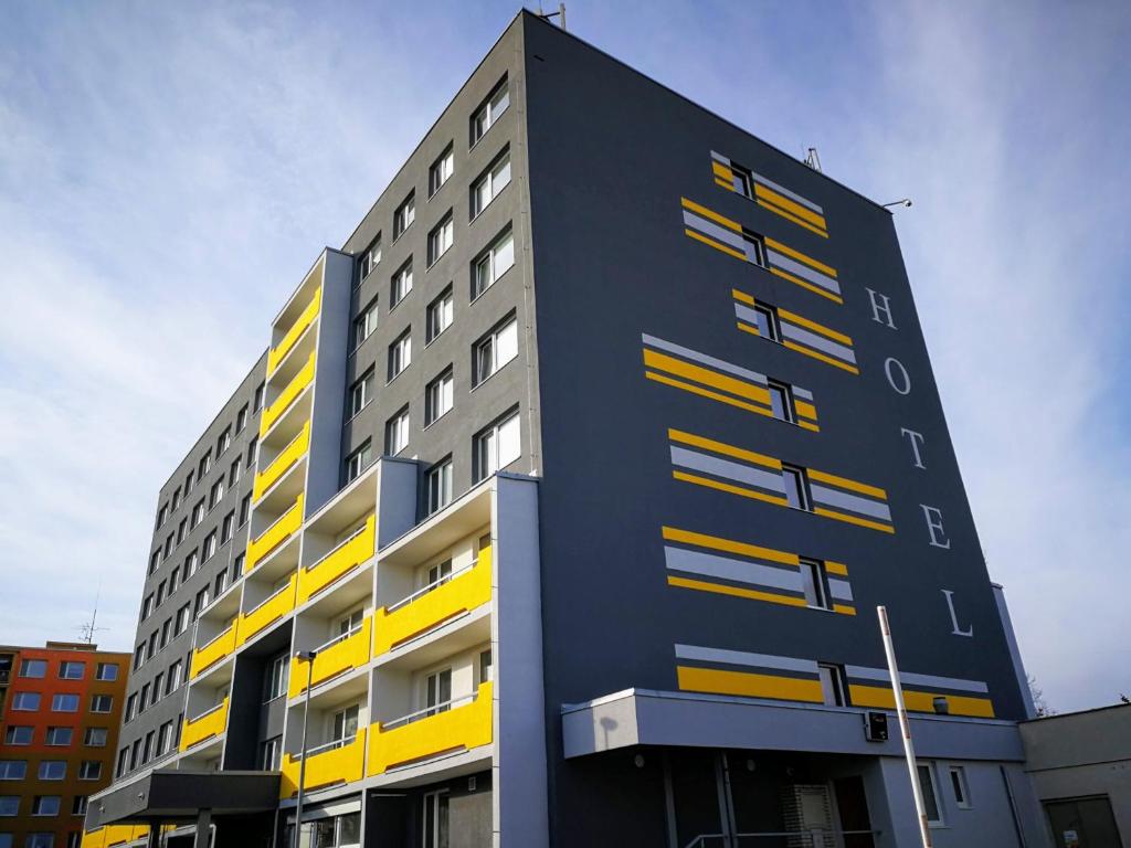 a tall building with yellow and black at Hotel Terek in Štětí