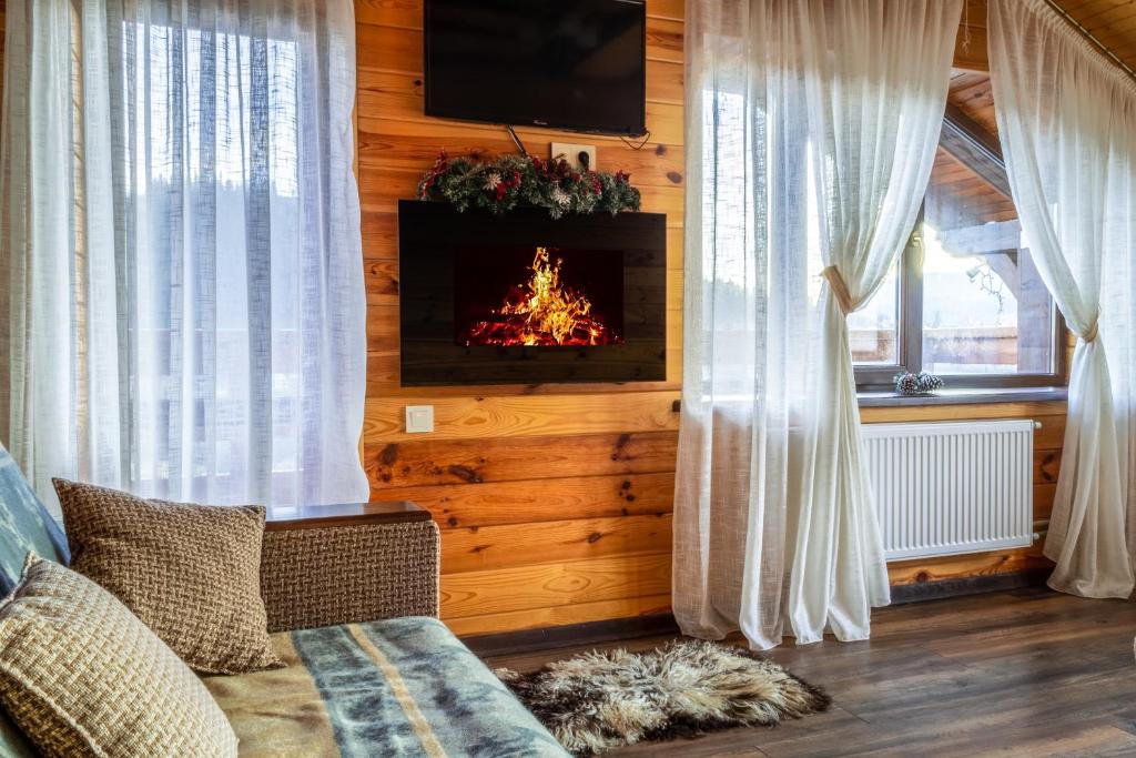 a living room with a fire in the fireplace at Cottage Chalet-Tiara in Slavske