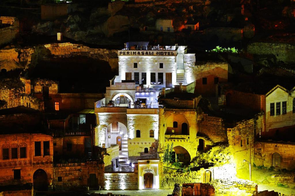 un gran edificio blanco iluminado por la noche en Perimasali Cave Hotel - Cappadocia, en Ürgüp