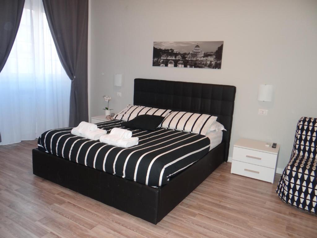 a bedroom with a black and white bed and a chair at VMH Vatican Modern House in Rome