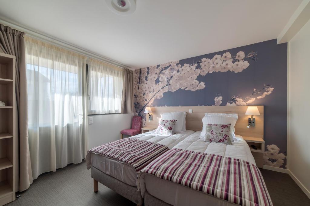 a bedroom with a large bed with a purple wall at Résidence les Dombes in Rillieux