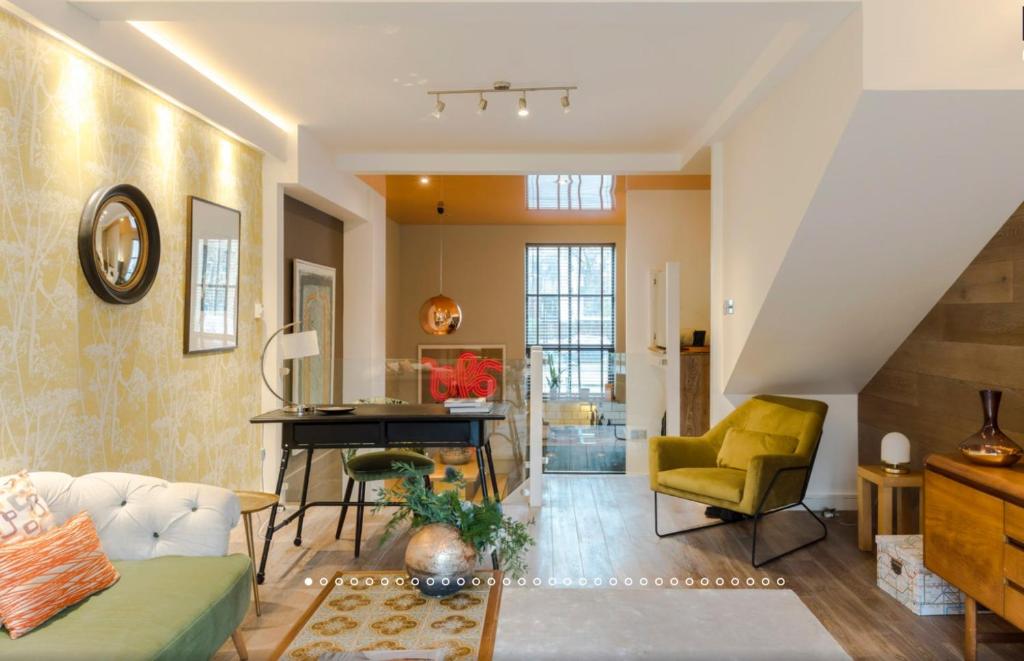 a living room with a piano and a yellow chair at Neon Melody - Playful 2 Bedrooms by London Bridge in London