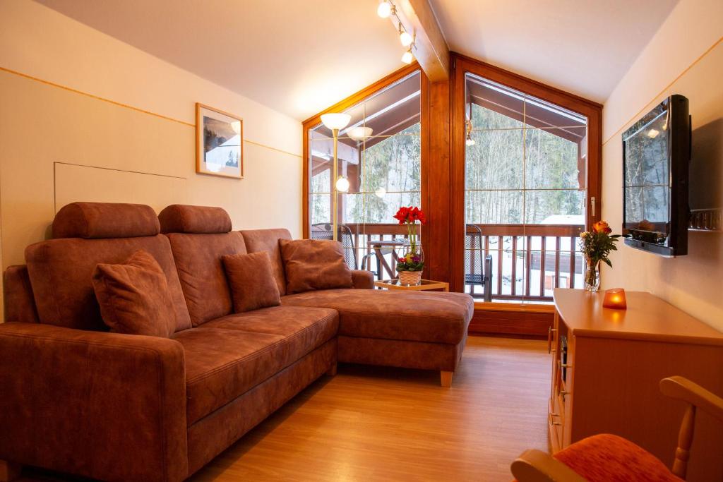 a living room with a couch and a large window at Fewo Boigs - Haus am Wandei in Bischofswiesen