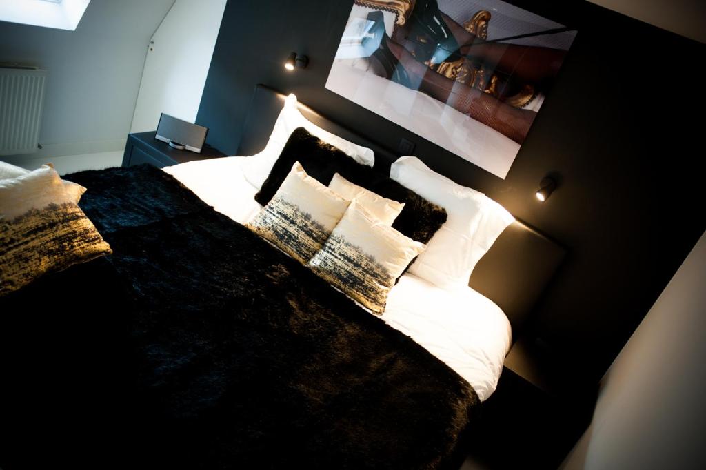 - une chambre dotée d'un grand lit avec des draps et des oreillers blancs dans l'établissement Lord of Ghent 2, à Gand