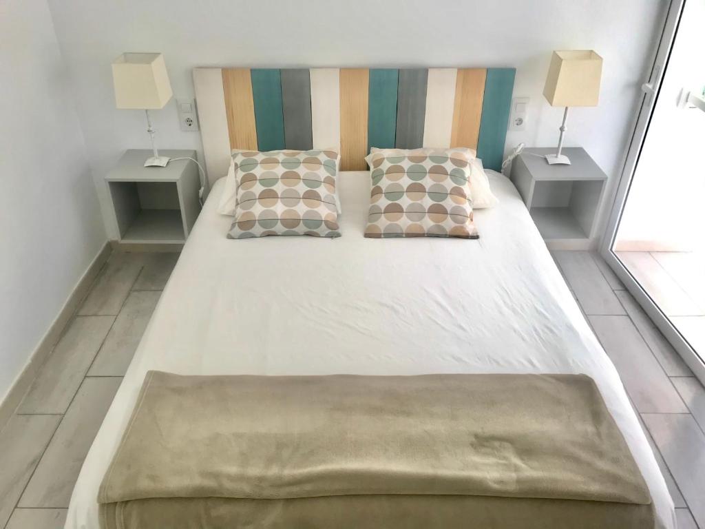 1 cama grande con 2 almohadas y 2 mesas en Caleta Soul Apartment, en Puerto de Santiago