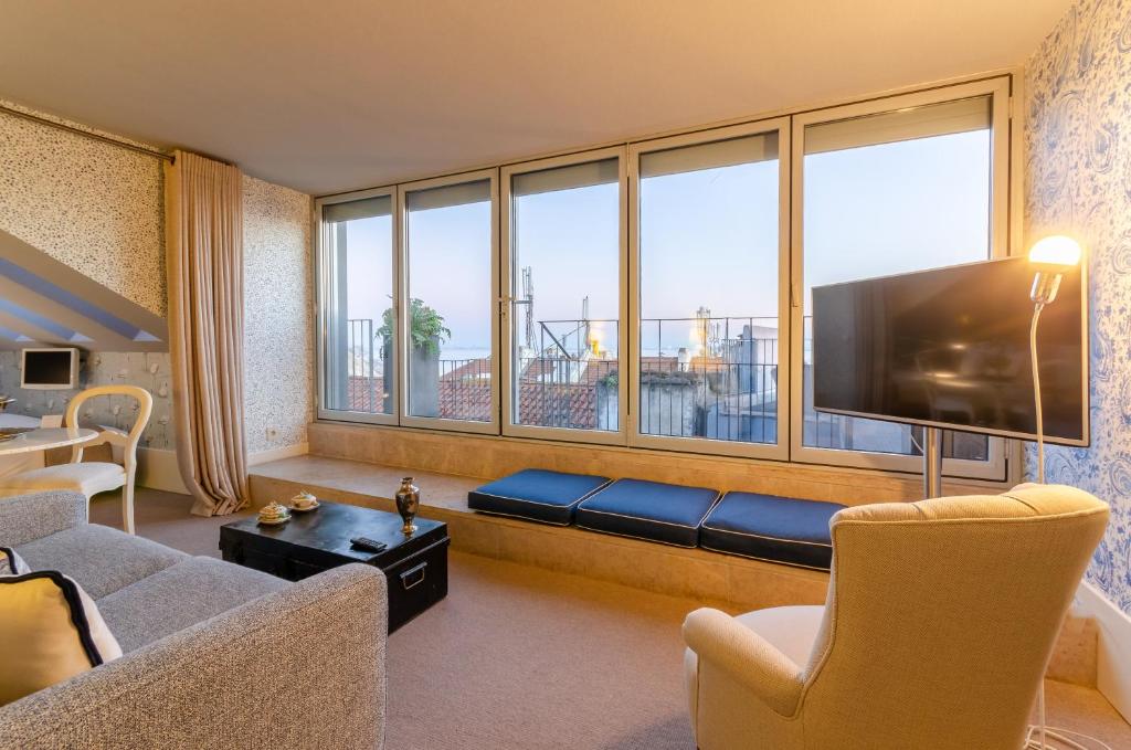een woonkamer met een bank en een groot raam bij Lx Boutique Hotel in Lissabon