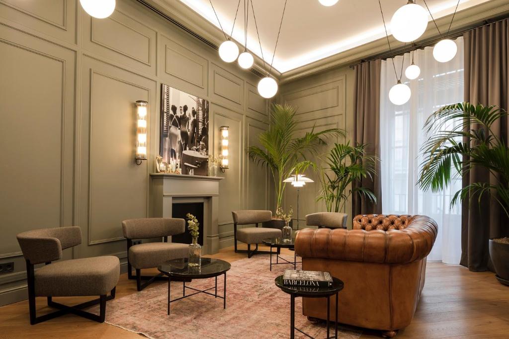 a living room with a couch and chairs and a fireplace at Maldà Singular Hotel in Barcelona