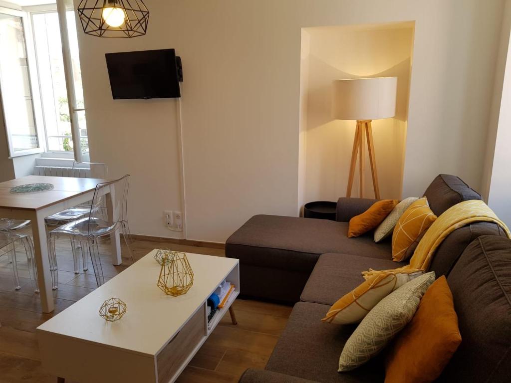 a living room with a couch and a table at Duplex en plein centre in Propriano