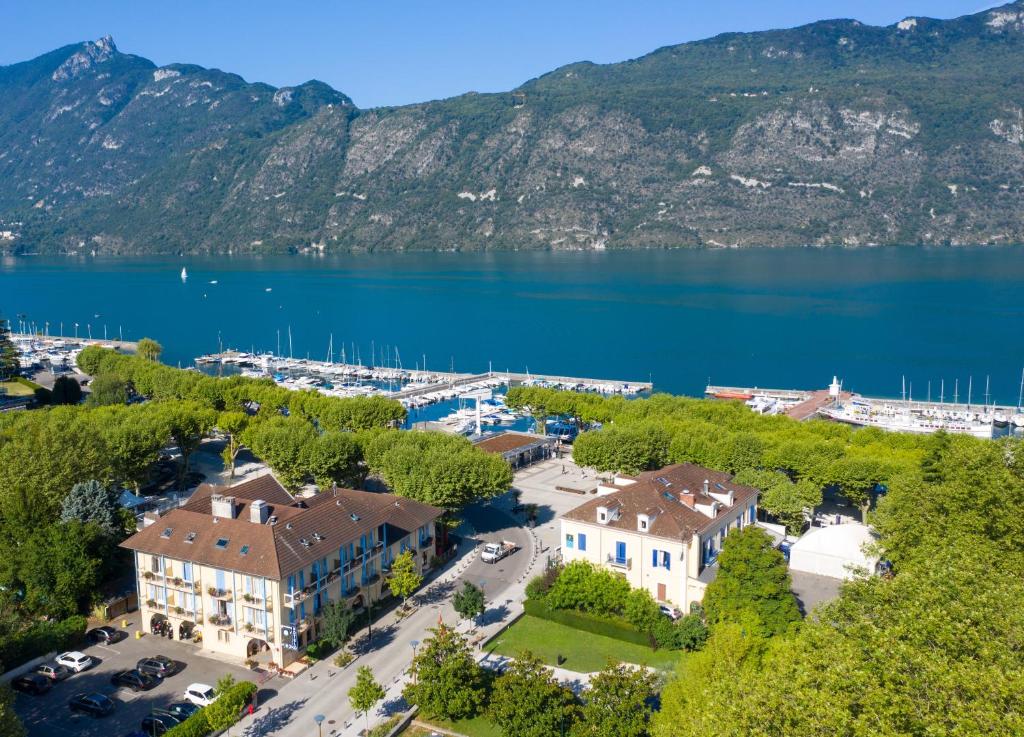 een luchtzicht op een resort met een meer en bergen bij Hôtel L'Iroko The Originals City in Aix-les-Bains