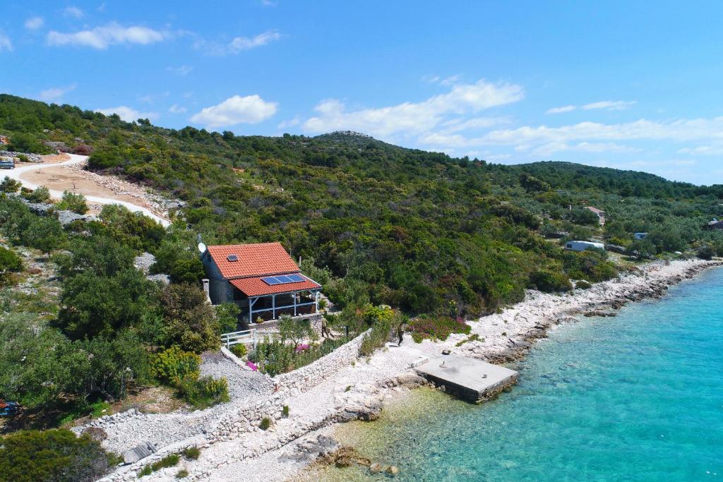 dom na kamienistej plaży obok wody w obiekcie House Starfish w mieście Pašman