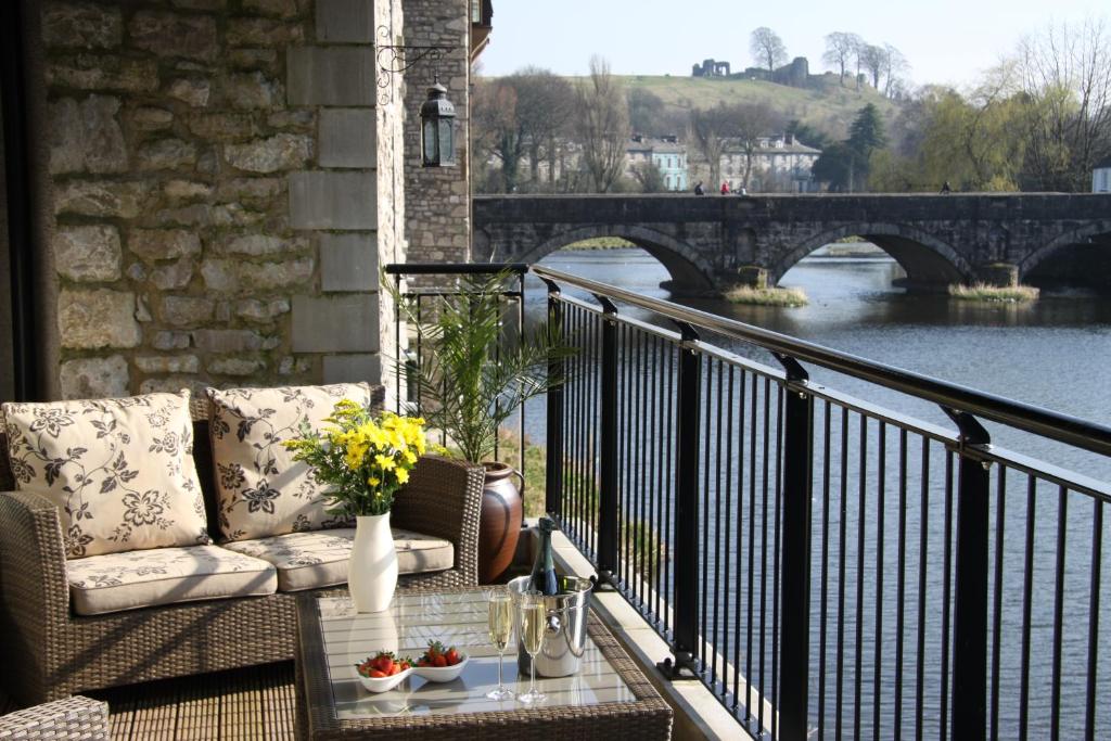 a balcony with a couch and a view of a bridge at Luxury riverside apartment in Kendal in Kendal
