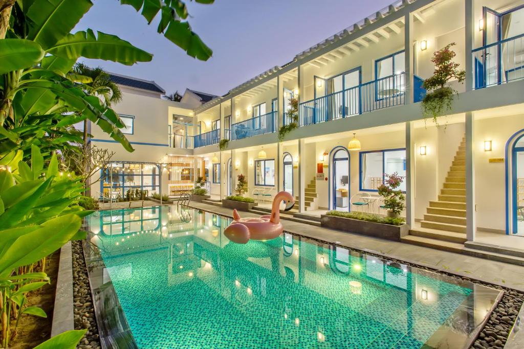 una piscina frente a un edificio con un juguete en el agua en Santorin HoiAn Villa en Hoi An