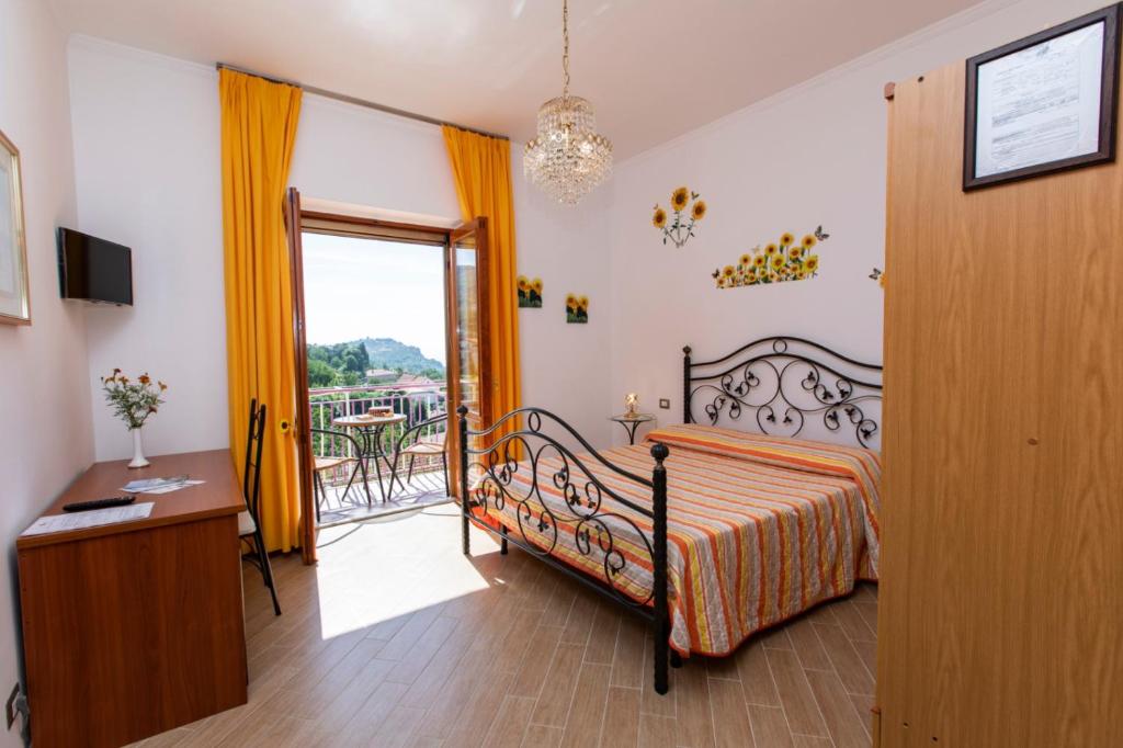 a bedroom with a bed and a desk and a balcony at Sant'Anna Bed & Breakfast in Agerola