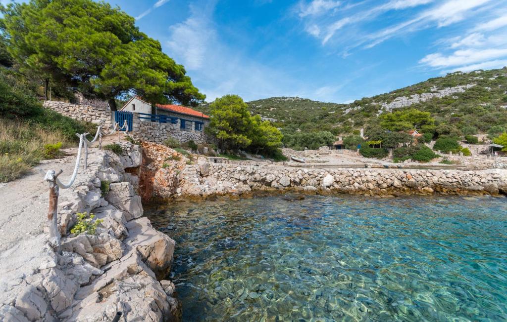 une masse d'eau à côté d'une rive rocheuse dans l'établissement House Island Harbour, à Pašman